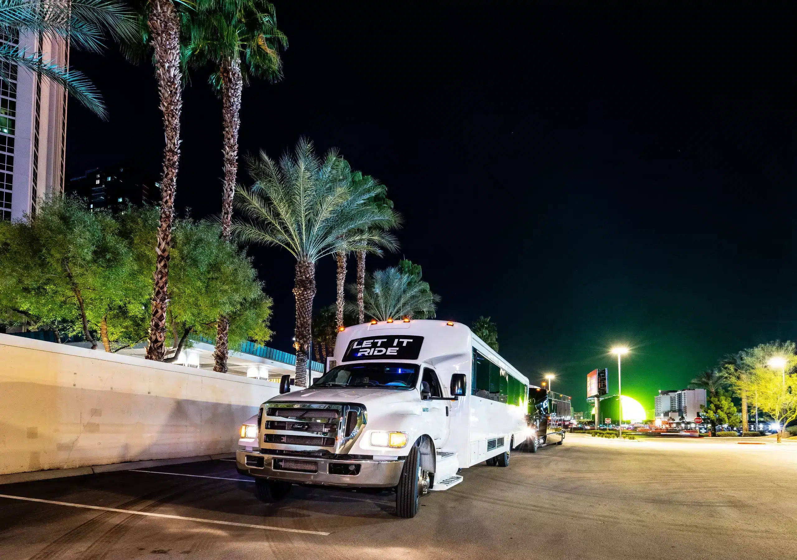 Let It Ride 38-passenger Las Vegas party bus glowing at night with vibrant interior lighting — ideal for nightlife groups.